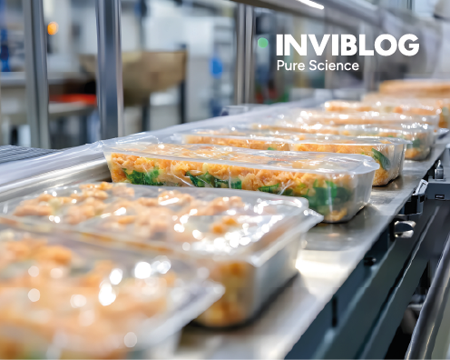 Packaged ready meals moving through a food production line, representing products where real‑time qPCR can detect hidden or processed fish allergens.